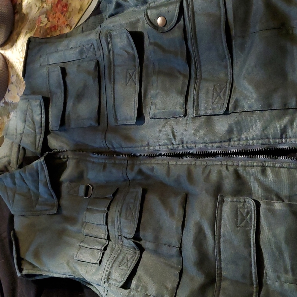 Man's outdoor vest.  Green outer side and plaid flannel inside.  Lot of pockets.